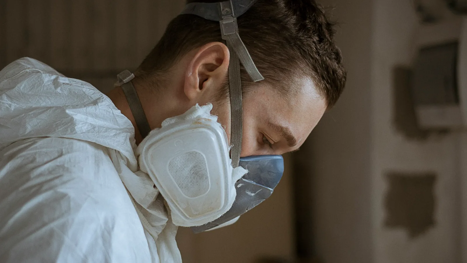 Technician in a protective suit and respirator during mold remediation, the labor behind most of the mold remediation cost